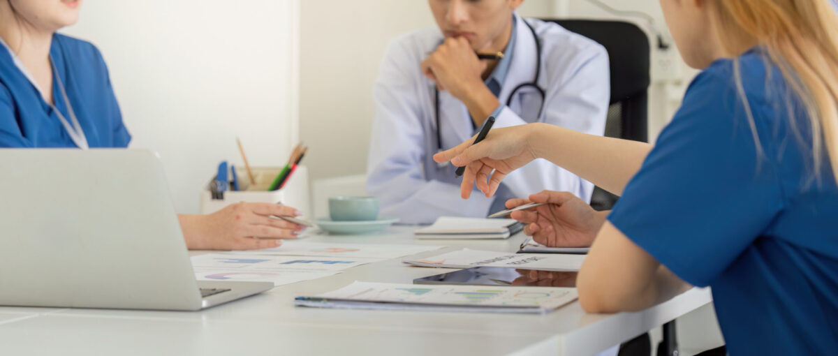 Team bestehend aus Krankenhauspersonal berät sich am Tisch