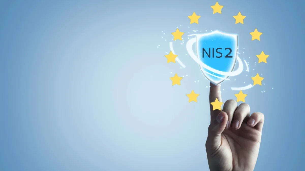 Hand berührt digitales Schild mit NIS2 Schriftzug und EU-Sternenkreis als Symbol für europäische Cybersicherheit
