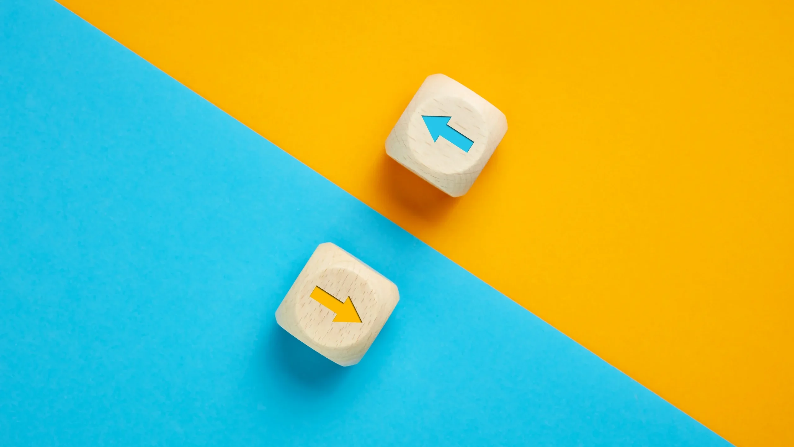 Arrow icons in contrast on wooden cubes moving towards opposite directions. Competition, diversity, opposition or confrontation concept.